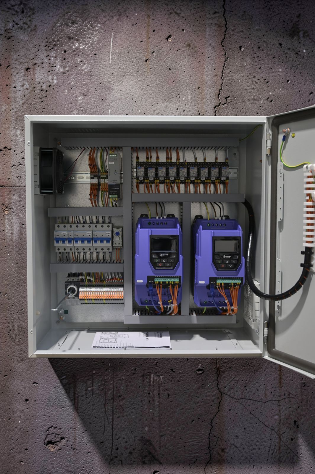 Twin booster set control panel with the door open showing two Invertek drives