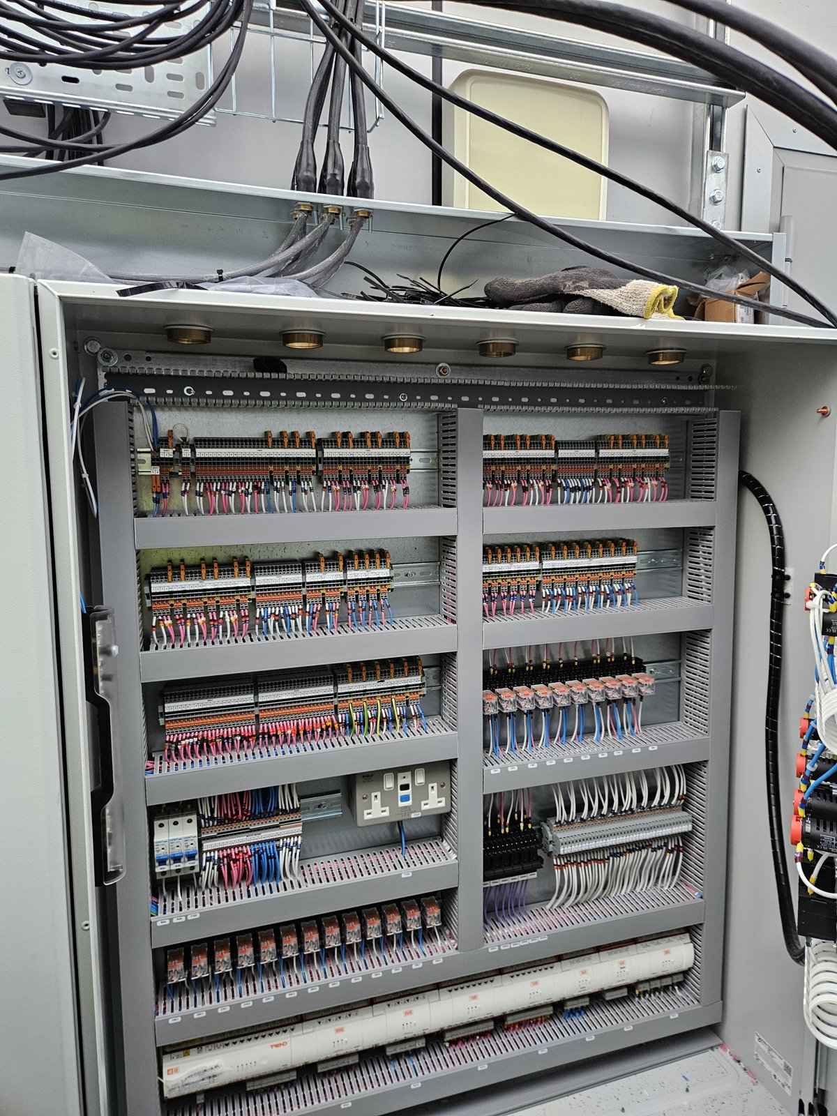 Inside the largest panel: rows of relays, controllers and labelled terminals on the backplate