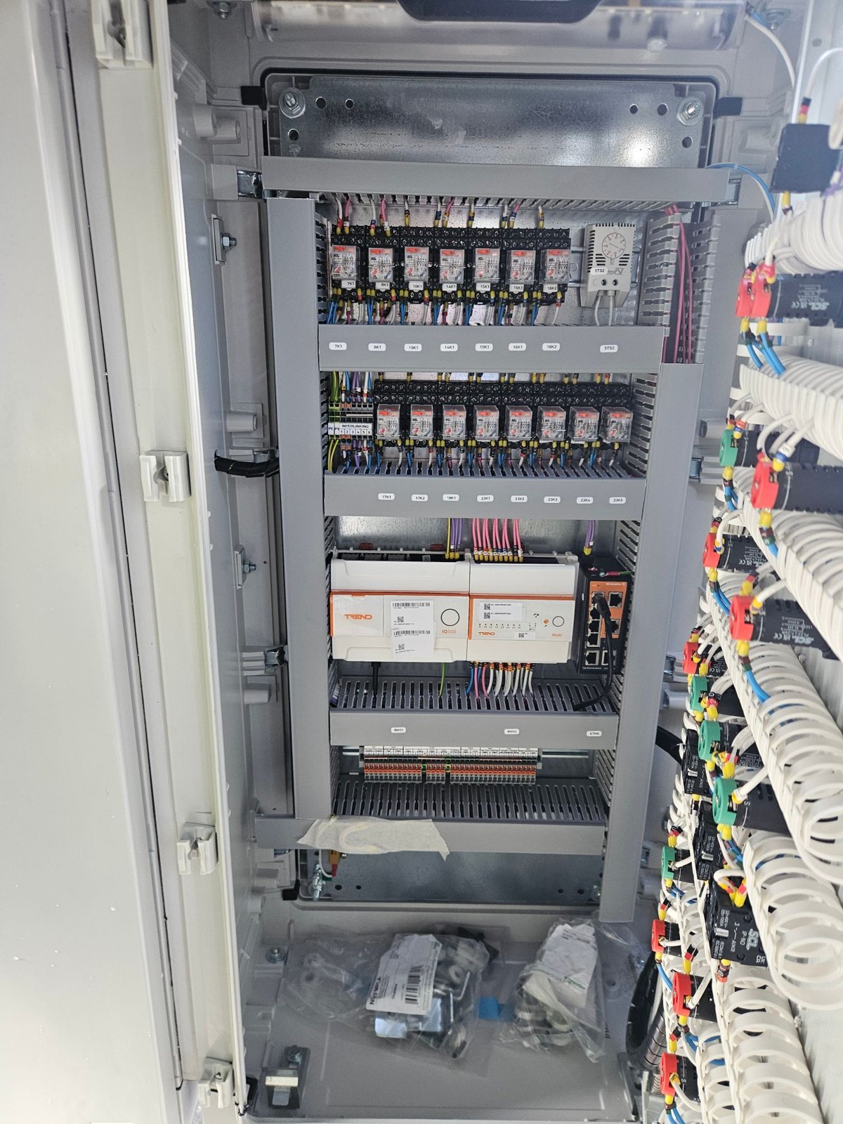 Inside the panel: interposing relays, Trend IQ controller and I/O module, network switch and BMS terminals